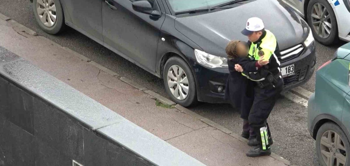 Trafik polisi yaralı kadını yağmurdan yelekle koruyarak taşıdı